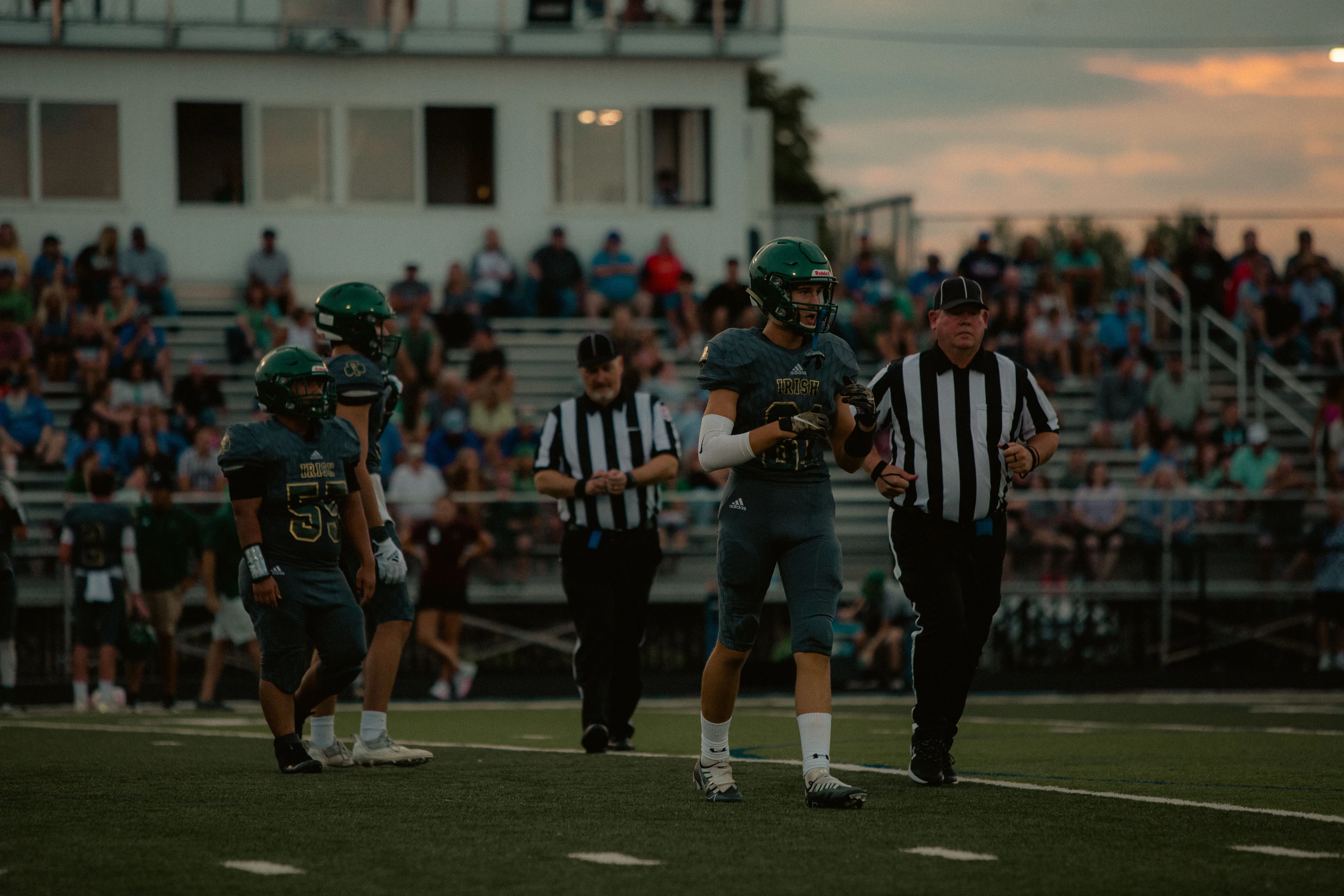 Football athletes and officials on the field during a game