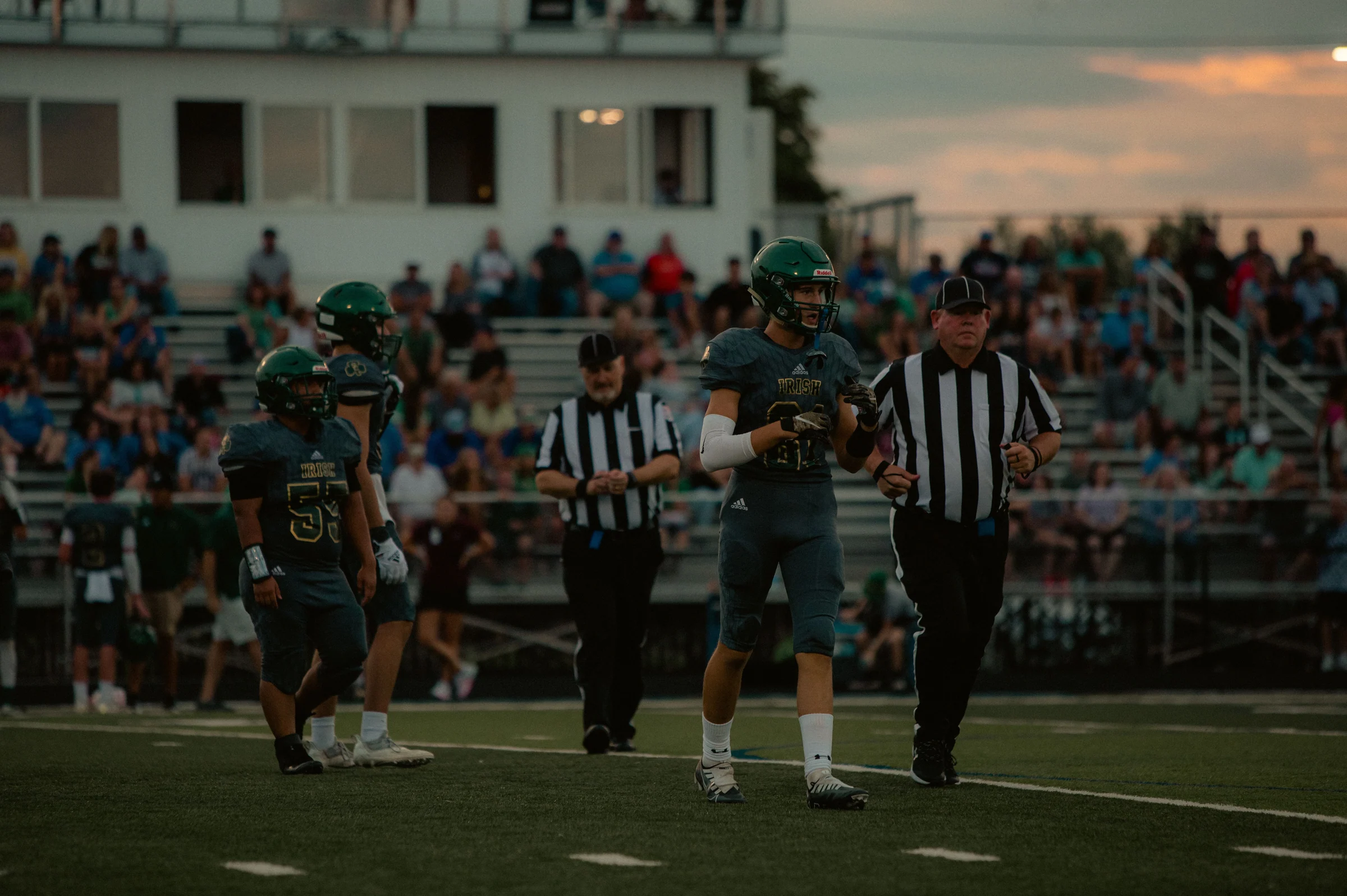 High-school football players and officials on the field